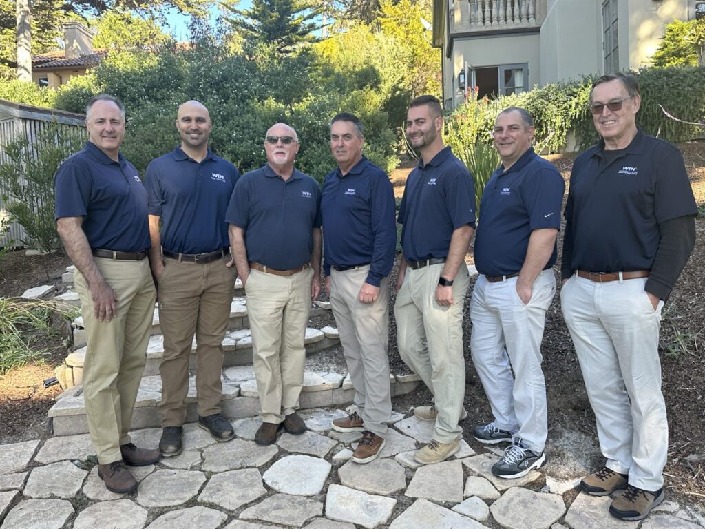 Group of WIN Home Inspectors in front of a house posing for the photo.
